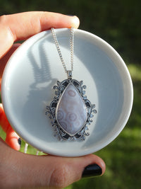 Handmade 925 sterling silver pendant with luna agate stone with orbicular patterns surrounded by hand-stamped and hand-sawed decorative branch accents lily and William jewelry