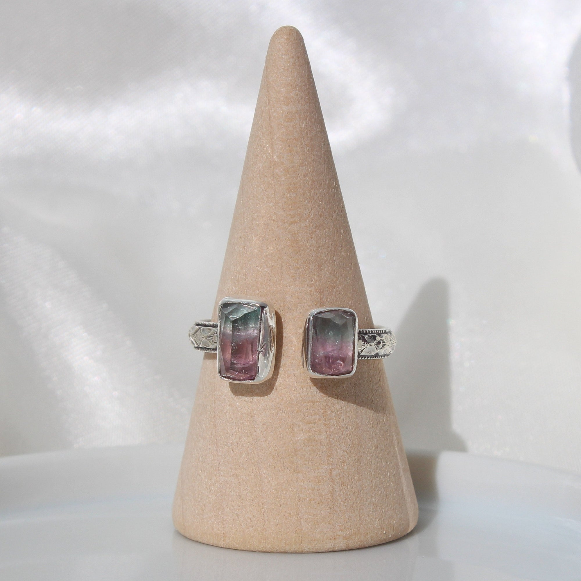 adjustable ring with two rectangular shaped faceted bi color watermelon tourmaline stones on a patterned band