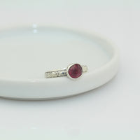 faceted pink tourmaline stone set in 999 fine silver and 925 sterling silver on a ornate pattern silver band ring size 5